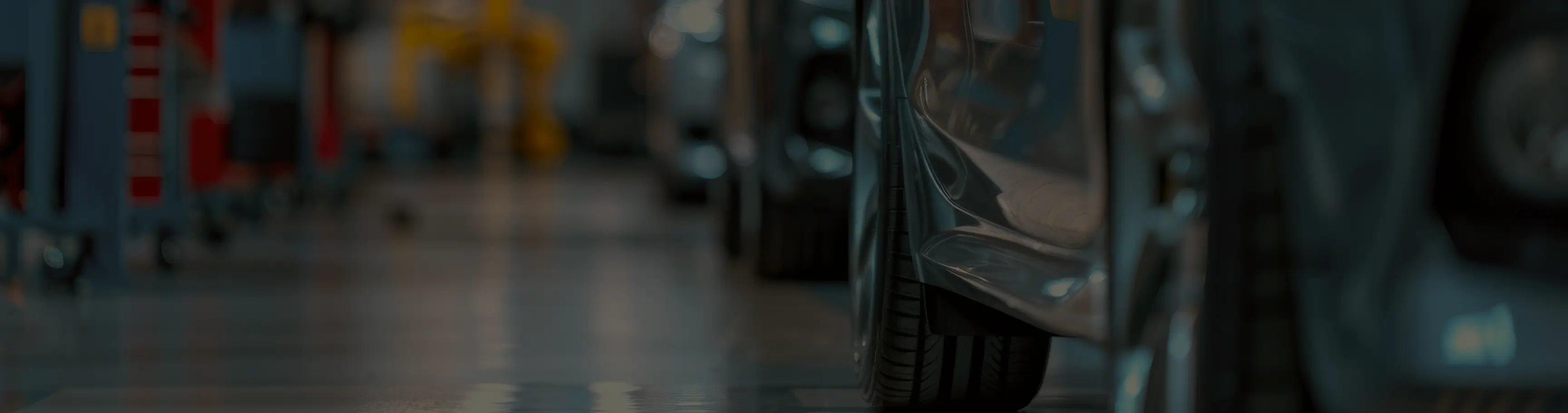 Blurred automotive repair shop interior with vehicles and professional equipment